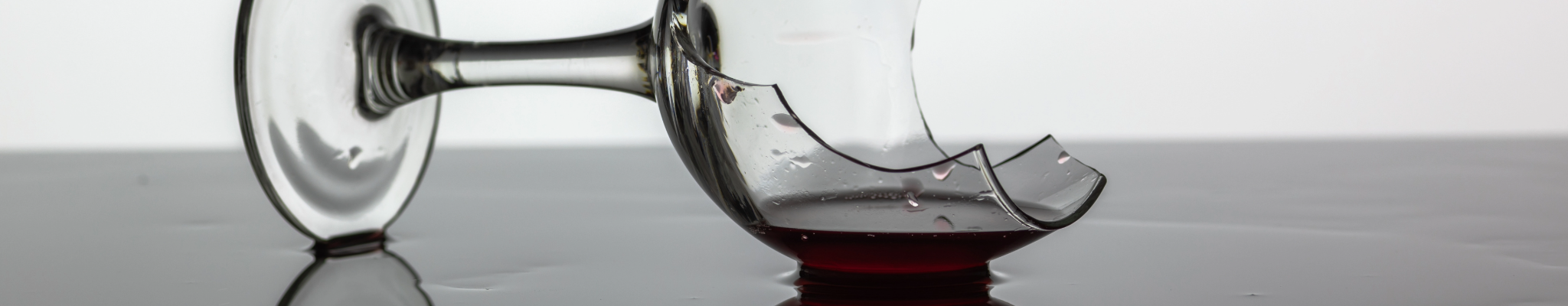 Seitlich liegendes, gebrochenes Weinglas