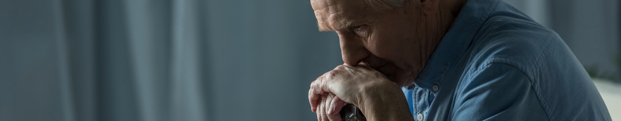 Älterer Mann sitzt ruhig auf Sofa