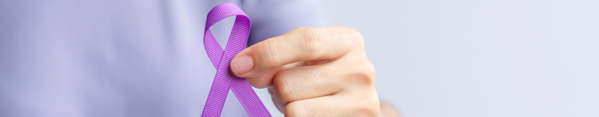 Eine Person hält eine lila Schliefe, das Symbol für den Interantional Overdose Awareness Day